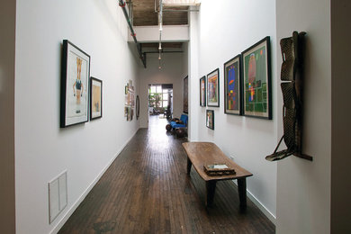 Entryway - large industrial medium tone wood floor entryway idea in Grand Rapids with white walls and a glass front door