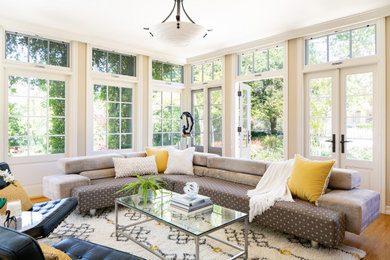 This is an example of a transitional sunroom in Los Angeles with medium hardwood floors and brown floor.