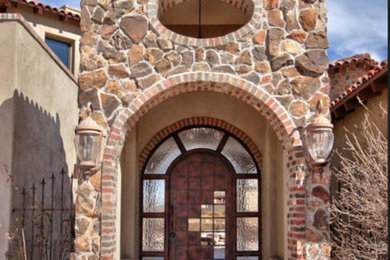 Inspiration for a large mediterranean beige two-story mixed siding exterior home remodel in Albuquerque with a hip roof