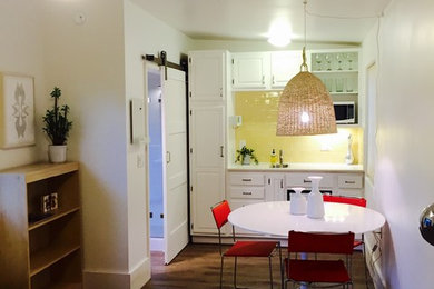 Example of a small eclectic galley kitchen design in Santa Barbara with ceramic backsplash, white appliances and no island