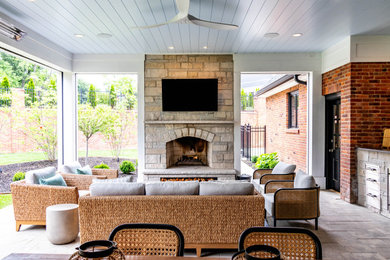 Mid-sized backyard concrete paver patio photo in St Louis with a fireplace and a roof extension