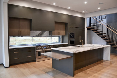 Large trendy light wood floor open concept kitchen photo in Other with an undermount sink, flat-panel cabinets, green cabinets, quartz countertops, window backsplash, paneled appliances, an island and green countertops