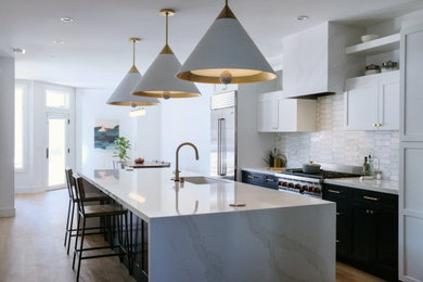 Light wood floor eat-in kitchen photo in San Francisco with an undermount sink, recessed-panel cabinets, quartz countertops, white backsplash, marble backsplash, stainless steel appliances, an island and white countertops