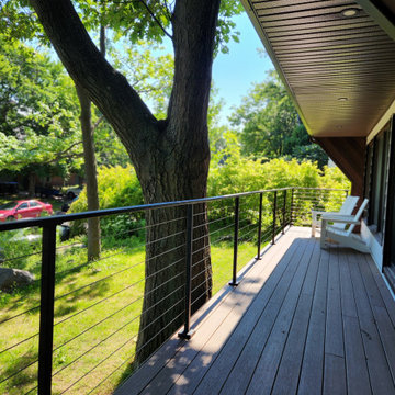 Deck with black metal post cable railing in Quebec, Canada