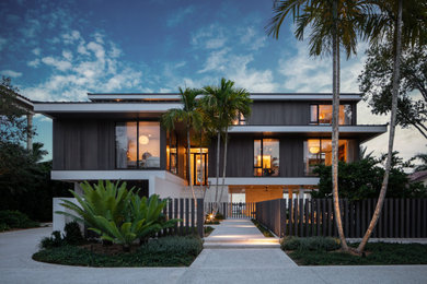 Example of a minimalist three-story wood exterior home design in Tampa