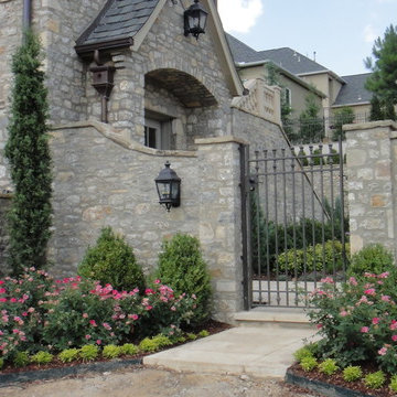 Iron gate set flanked by landscaping