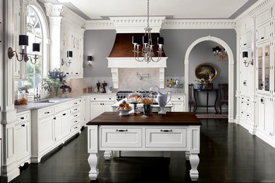 Inspiration for a large timeless u-shaped dark wood floor enclosed kitchen remodel in Jackson with an undermount sink, recessed-panel cabinets, white cabinets, marble countertops, gray backsplash, stone tile backsplash, paneled appliances and two islands