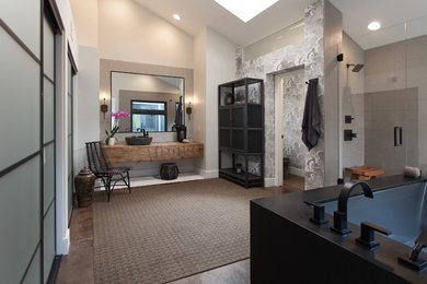 This is an example of a large contemporary master bathroom in Orange County with a corner tub, an alcove shower, grey walls, concrete floors, a vessel sink, open cabinets, dark wood cabinets, beige tile and wood benchtops.