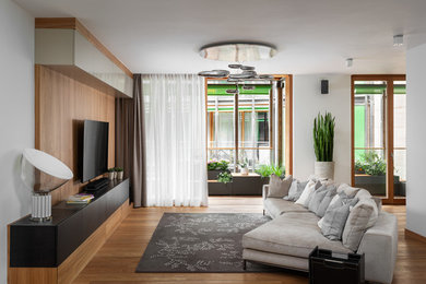 Idee per un soggiorno minimalista di medie dimensioni e aperto con pavimento in legno massello medio e TV a parete