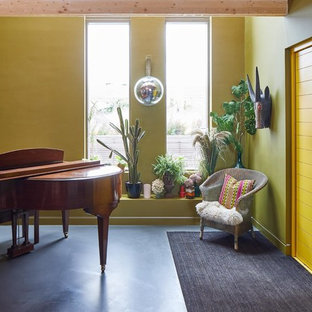 Idée de décoration pour un hall d'entrée bohème de taille moyenne avec un mur jaune, un sol en linoléum, une porte simple, une porte jaune et un sol noir.
