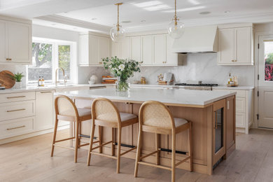 Inspiration for a large contemporary u-shaped light wood floor and beige floor eat-in kitchen remodel in Orange County with an undermount sink, shaker cabinets, beige cabinets, quartzite countertops, white backsplash, stone slab backsplash, stainless steel appliances, an island and white countertops