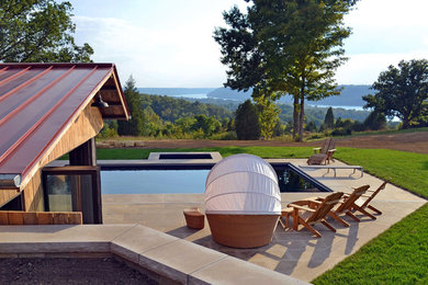 This is an example of a mid-sized modern full sun backyard stone landscaping in Louisville.