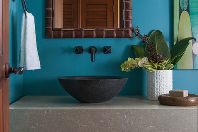 Photo of a mid-sized tropical bathroom in Hawaii with a vessel sink and blue walls.