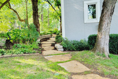 Immagine di un giardino in ombra dietro casa in estate con un ingresso o sentiero e pavimentazioni in pietra naturale