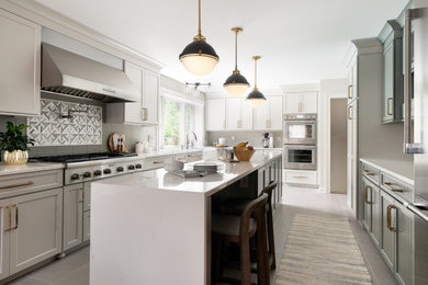 Example of a mid-sized transitional u-shaped ceramic tile and gray floor eat-in kitchen design in New York with a farmhouse sink, beaded inset cabinets, green cabinets, quartz countertops, green backsplash, glass tile backsplash, stainless steel appliances, an island and beige countertops