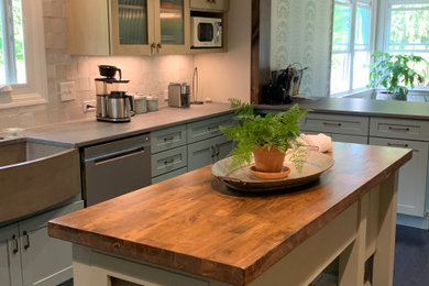 Example of a mid-sized transitional galley painted wood floor and blue floor eat-in kitchen design with a farmhouse sink, recessed-panel cabinets, blue cabinets, quartz countertops, gray backsplash, ceramic backsplash, colored appliances and an island