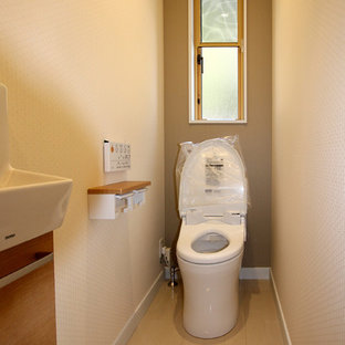 Idee per un piccolo bagno di servizio moderno con ante in legno scuro, WC monopezzo, pareti beige, pavimento in compensato e pavimento bianco