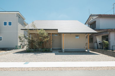 Imagen de fachada beige minimalista de dos plantas con tejado a dos aguas