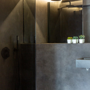 Inspiration for a medium sized bohemian look-out basement in London with pink walls, concrete flooring, no fireplace, a plastered fireplace surround and grey floors.