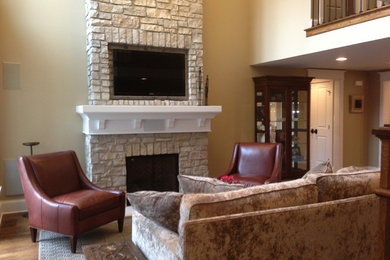 Inspiration for a small timeless medium tone wood floor and brown floor living room remodel in Chicago with beige walls, a standard fireplace, a brick fireplace and a wall-mounted tv