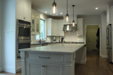 Inspiration for a mid-sized transitional l-shaped dark wood floor and brown floor eat-in kitchen remodel in Bridgeport with an undermount sink, recessed-panel cabinets, white cabinets, soapstone countertops, white backsplash, porcelain backsplash and an island