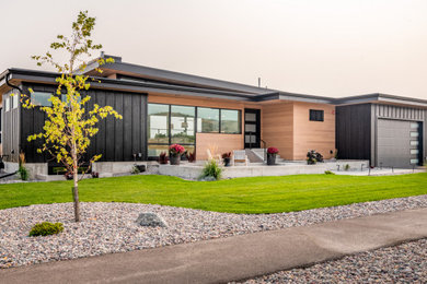 Mid-sized modern black two-story mixed siding and board and batten exterior home idea in Other with a metal roof and a black roof