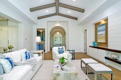 Large beach style open concept light wood floor living room photo in Miami with white walls