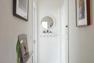 Mid-sized contemporary hallway in Dublin with white walls, vinyl floors and beige floor.