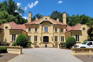 Example of a large tuscan two-story house exterior design in Atlanta with a hip roof and a tile roof