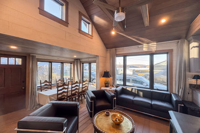 Living room - small rustic medium tone wood floor, brown floor, exposed beam and wood wall living room idea in Bridgeport with beige walls and a wood stove