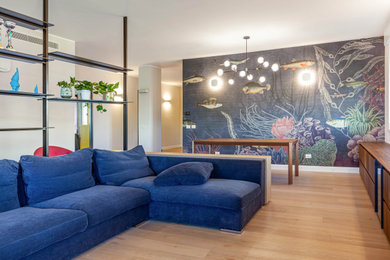 Diseño de salón abierto moderno grande con paredes blancas, suelo de madera clara, televisor colgado en la pared, suelo marrón y papel pintado