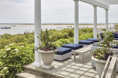 Example of a patio design in Boston with a pergola