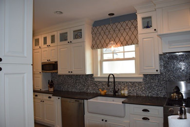 Mid-sized elegant kitchen photo in New York with raised-panel cabinets, white cabinets, quartz countertops, multicolored backsplash, glass tile backsplash, an island and gray countertops