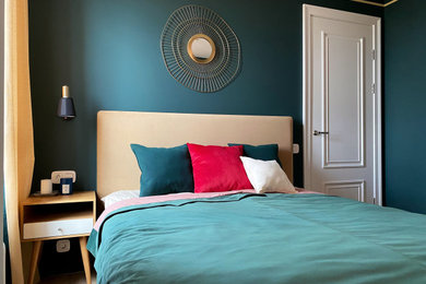 Diseño de dormitorio actual con paredes verdes y suelo laminado