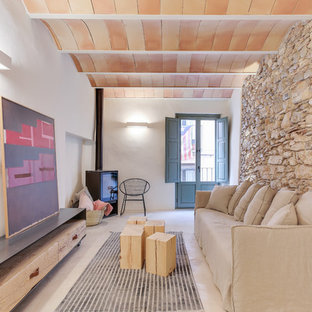 Mittelgroßes, Fernseherloses Mediterranes Wohnzimmer mit weißer Wandfarbe, Betonboden, Kaminofen und grauem Boden in Sonstige