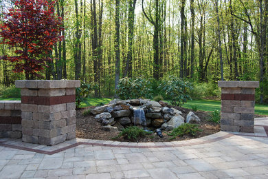 Patio fountain - mid-sized transitional backyard brick patio fountain idea in Other with no cover
