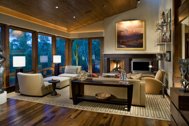 Inspiration for a mid-sized contemporary formal and enclosed medium tone wood floor and brown floor living room remodel in Denver with a standard fireplace, a wall-mounted tv, beige walls and a metal fireplace
