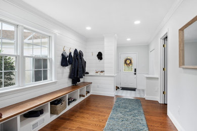 Mid-sized enclosed light wood floor, brown floor and shiplap wall living room photo in Philadelphia with white walls, a standard fireplace, a stone fireplace and a wall-mounted tv