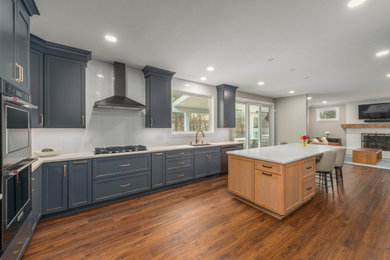 Example of a large trendy u-shaped vinyl floor eat-in kitchen design in Cleveland with shaker cabinets, blue cabinets, quartz countertops, white backsplash, ceramic backsplash, an island and white countertops