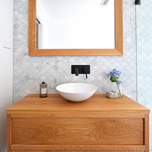 Immagine di una piccola stanza da bagno padronale minimalista con consolle stile comò, ante in legno chiaro, zona vasca/doccia separata, WC monopezzo, piastrelle bianche, piastrelle di cemento, pareti grigie, pavimento con piastrelle in ceramica, lavabo a bacinella, top in legno, pavimento grigio, porta doccia a battente e top marrone