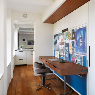 Foto di un piccolo ufficio minimal con pareti bianche, pavimento in legno massello medio e scrivania incassata
