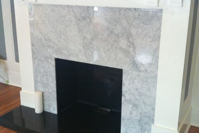 Example of a living room design in New York with a standard fireplace and a stone fireplace