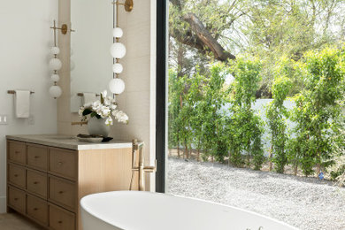 Freestanding bathtub - large contemporary master beige tile single-sink freestanding bathtub idea in Phoenix with beaded inset cabinets, light wood cabinets and a built-in vanity