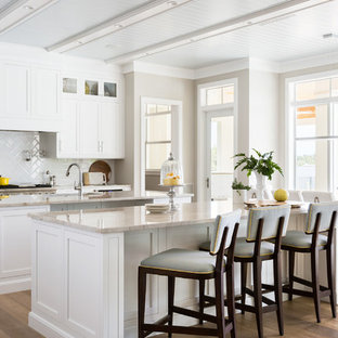 Große, Zweizeilige Maritime Wohnküche mit Unterbauwaschbecken, Schrankfronten im Shaker-Stil, weißen Schränken, Quarzit-Arbeitsplatte, Küchenrückwand in Weiß, Elektrogeräten mit Frontblende, hellem Holzboden, zwei Kücheninseln und braunem Boden in Miami