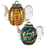 Dale Tiffany - Dale Tiffany 2-Piece Inferno Hand Blown Art Glass Tea Pot Sculpture - This captivating 2 Piece Teapot Set is a thoughtful gift, sure to be appreciated by any recipient; even when that recipient is you. The set includes a pair of decorative teapots. The first features a body of golden amber crackle glass that is overlaid with a freeform patchwork of deep honey amber. The body of the second pot is a mesmerizing swirl of vivid blue, warm amber, and bright white that is then topped with black spots. Each pot features a clear glass neck and spout at its top, along with a clear spout and handle that is gently scalloped. Both pots are hand-blown using Favrile Art Glass, which means the color is embedded within the glass. This ensures that no 2 pieces are exactly alike and you can be assured that yours is a one of a kind work of art. The perfect gift for any tea aficionado, mother, sister or favorite aunt, our 2 Piece Teapot Set will be a cherished keepsake to be proudly displayed for many years to come.