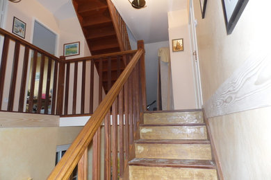Aménagement d'un escalier classique avec des marches en bois peint, des contremarches en bois et un garde-corps en bois.