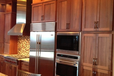 Large trendy medium tone wood floor kitchen photo in Other with an undermount sink, shaker cabinets, medium tone wood cabinets, granite countertops, beige backsplash, mosaic tile backsplash, stainless steel appliances and an island