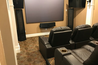 Home theater - mid-sized traditional enclosed carpeted and beige floor home theater idea in Dallas with brown walls and a projector screen