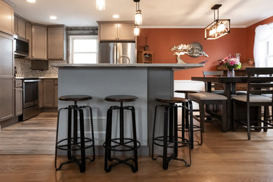 Eat-in kitchen - mid-sized modern l-shaped brown floor eat-in kitchen idea in Baltimore with shaker cabinets, gray cabinets, multicolored backsplash, an island and an undermount sink