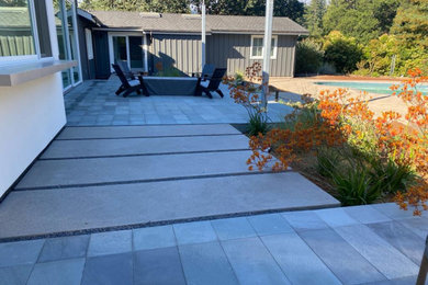 Foto de patio moderno de tamaño medio sin cubierta en patio trasero con cocina exterior y adoquines de piedra natural